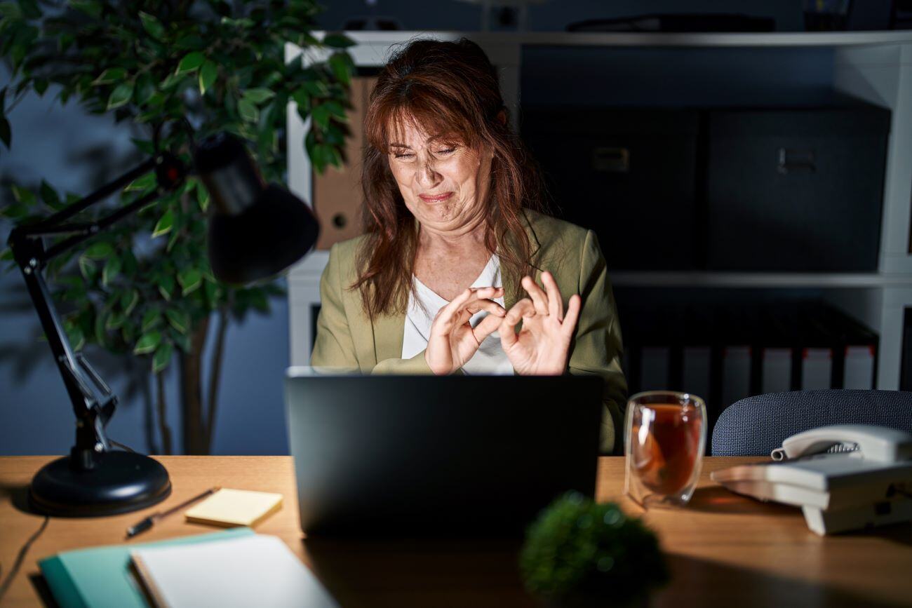 Middle age woman working using computer laptop with disgusted expression